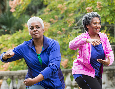 Active senior women doing functional fitness exercises outdoors, showcasing healthy aging and resilience